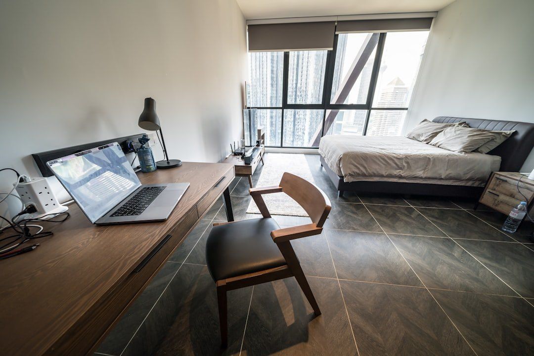 Helles Apartment mit Schreibtisch und aufgeklapptem Laptop.