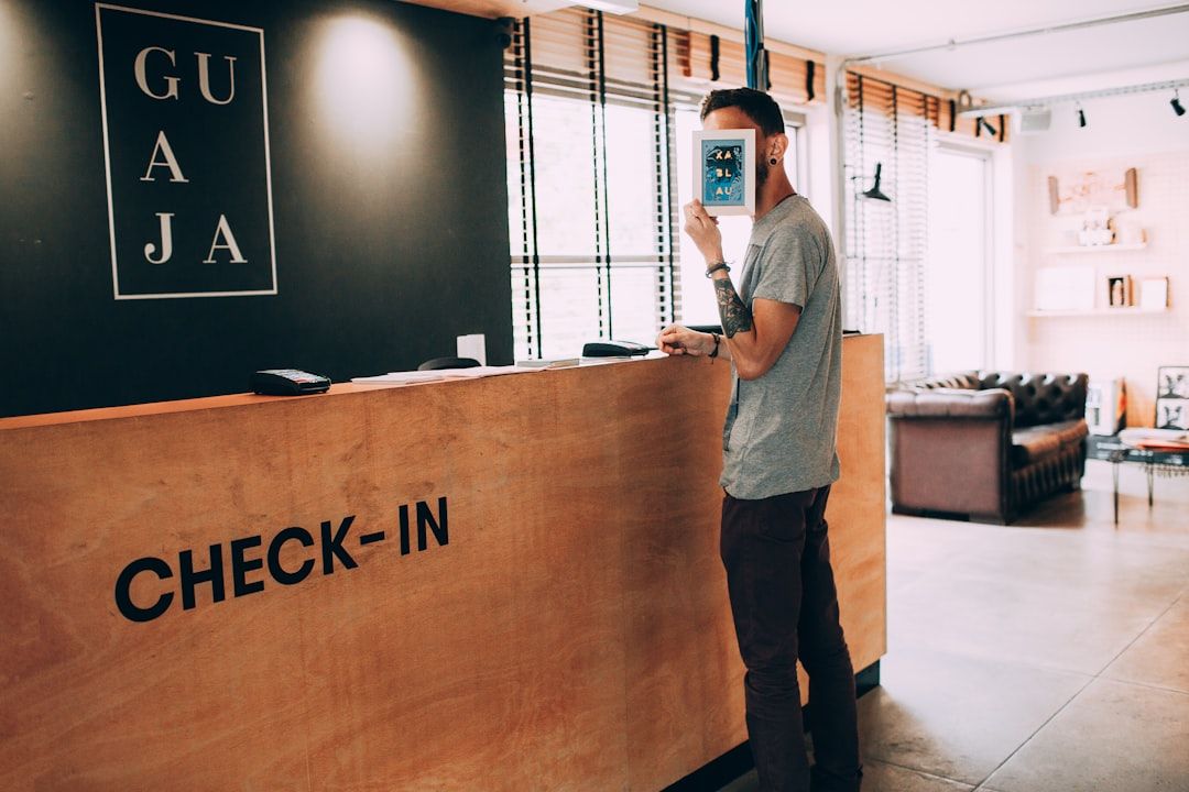 Gast mit Smartphone vor einem Check-in-Schalter.