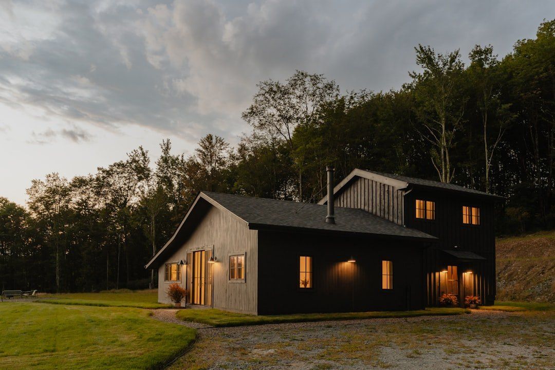 Ferienhaus mit warm beleuchteten Fenstern in der Dämmerung.