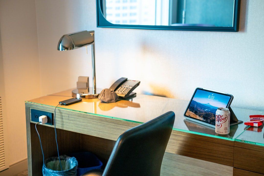 Schreibtisch in einem Hotelzimmer mit Tablet und Telefon.